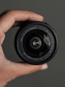 Nikon AF-P DX NIKKOR 18-55mm cameralens in een hand