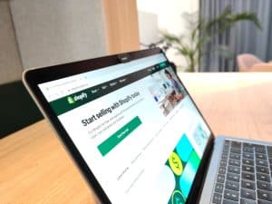 Laptop met de Shopify-startpagina en knop ‘Start free trial’ op een bureau