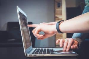 Twee mensen gebruiken samen een laptop, één wijst naar het scherm